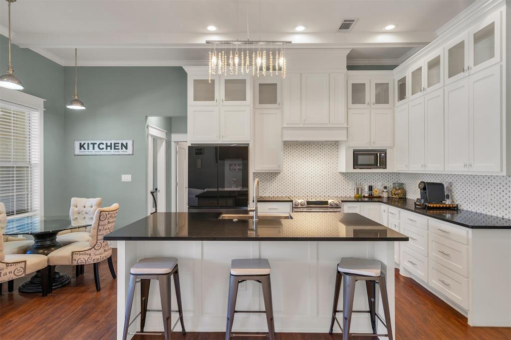 300 West Bell Street Everman, TX 76140 - Photo 7 of 28 a kitchen with stainless steel appliances granite countertop a stove top oven a sink a dining table and chairs