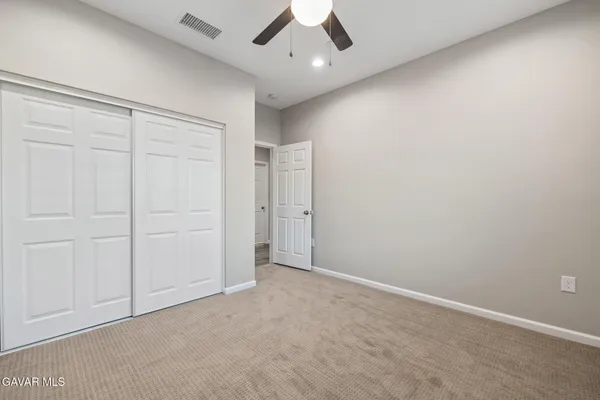 an empty room with a window and a fan