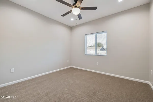 an empty room with a ceiling fan and a window