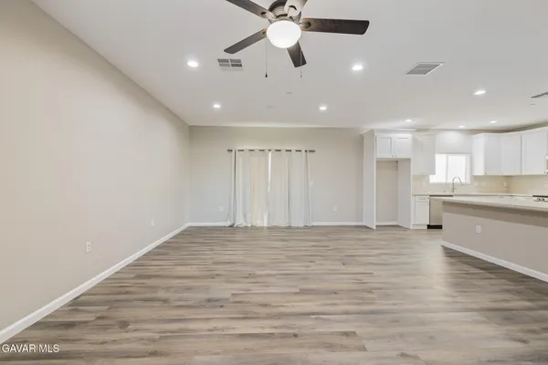 a kitchen with wooden floors and white stainless steel appliances