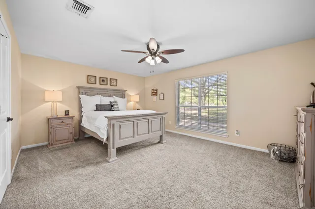 a spacious bedroom with a bed and a ceiling fan