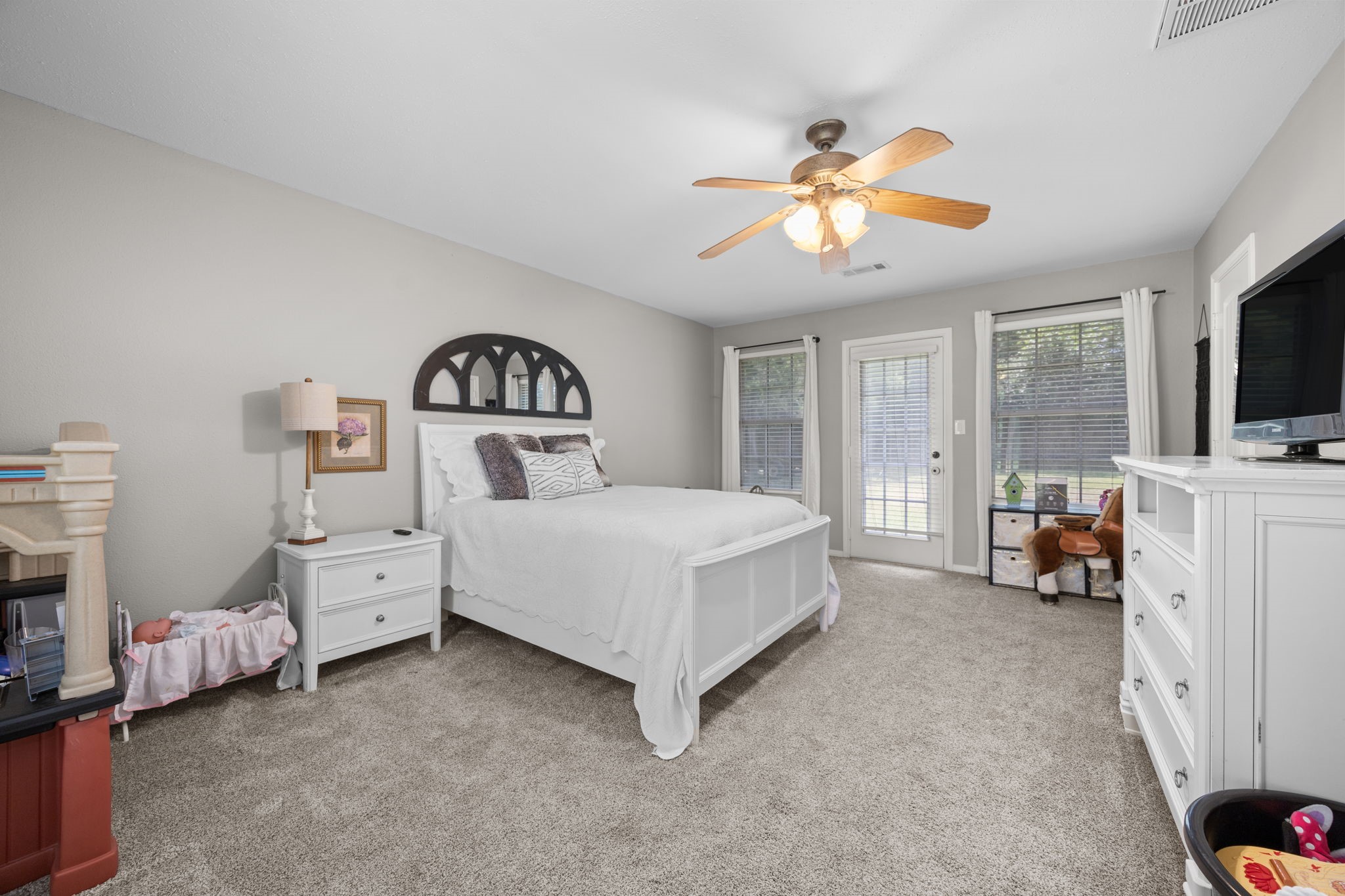 3311 Eula Morgan Road Katy, TX 77493 - Photo 30 of 32 a spacious bedroom with a bed and a flat tv screen on dresser
