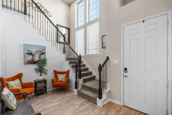 a living room with furniture kitchen area and a window