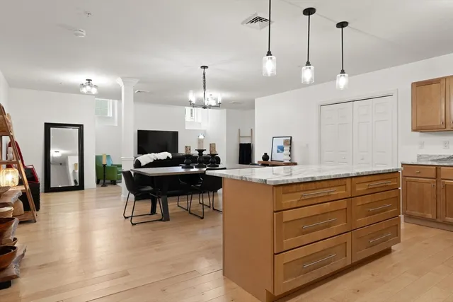 a kitchen with stainless steel appliances granite countertop a sink a stove and a wooden floor