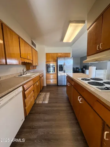 a large kitchen with stainless steel appliances granite countertop a lot of counter space and a sink