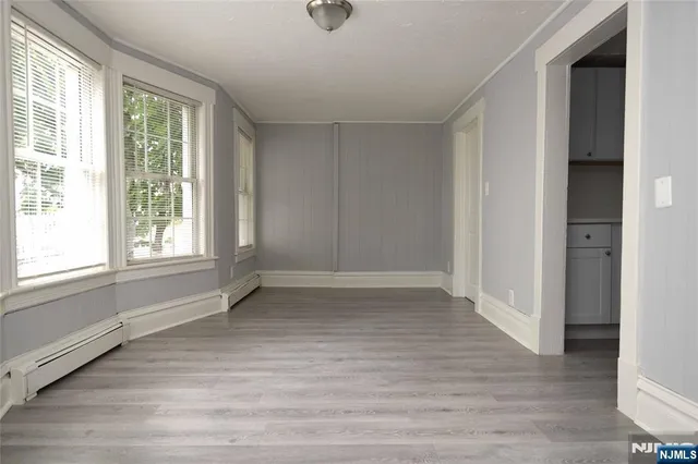 an empty room with wooden floor and window