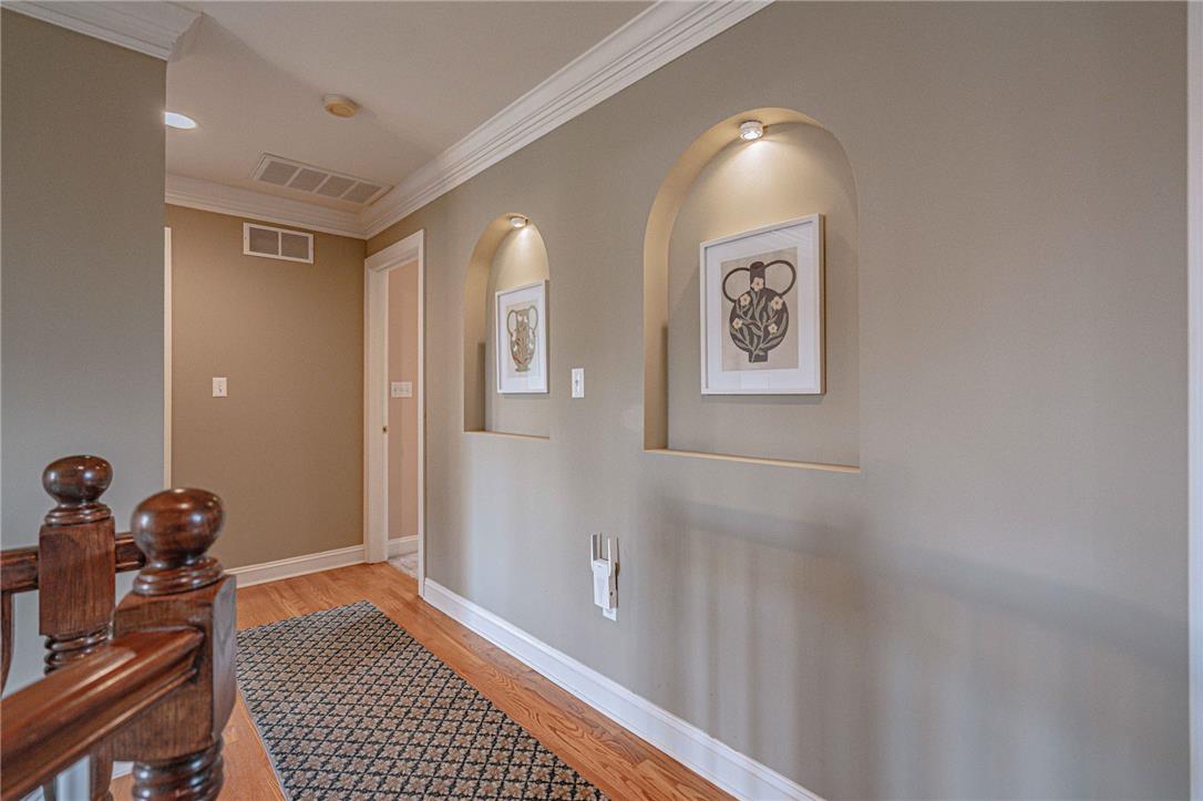 6000 Pond View Terrace Bath, PA 18014 - Photo 34 of 69 Hardwood flooring extends through this gracefully lit hallway, featuring elegant crown molding and recessed wall niches.