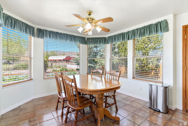 72 Canal Bank Road Garland, UT 84312 - Photo 13 of 40 Dining area featuring a bay window with multiple panes, ceramic tile flooring, and a ceiling fan with integrated lighting