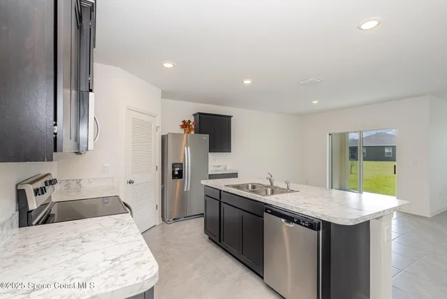 a kitchen with stainless steel appliances granite countertop a sink stove and refrigerator