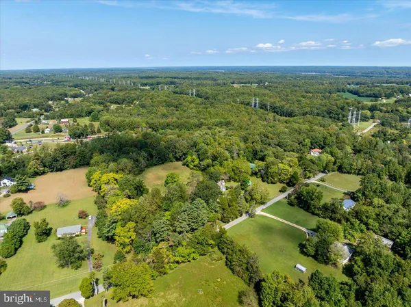 an aerial view of residential houses with outdoor space and trees all around