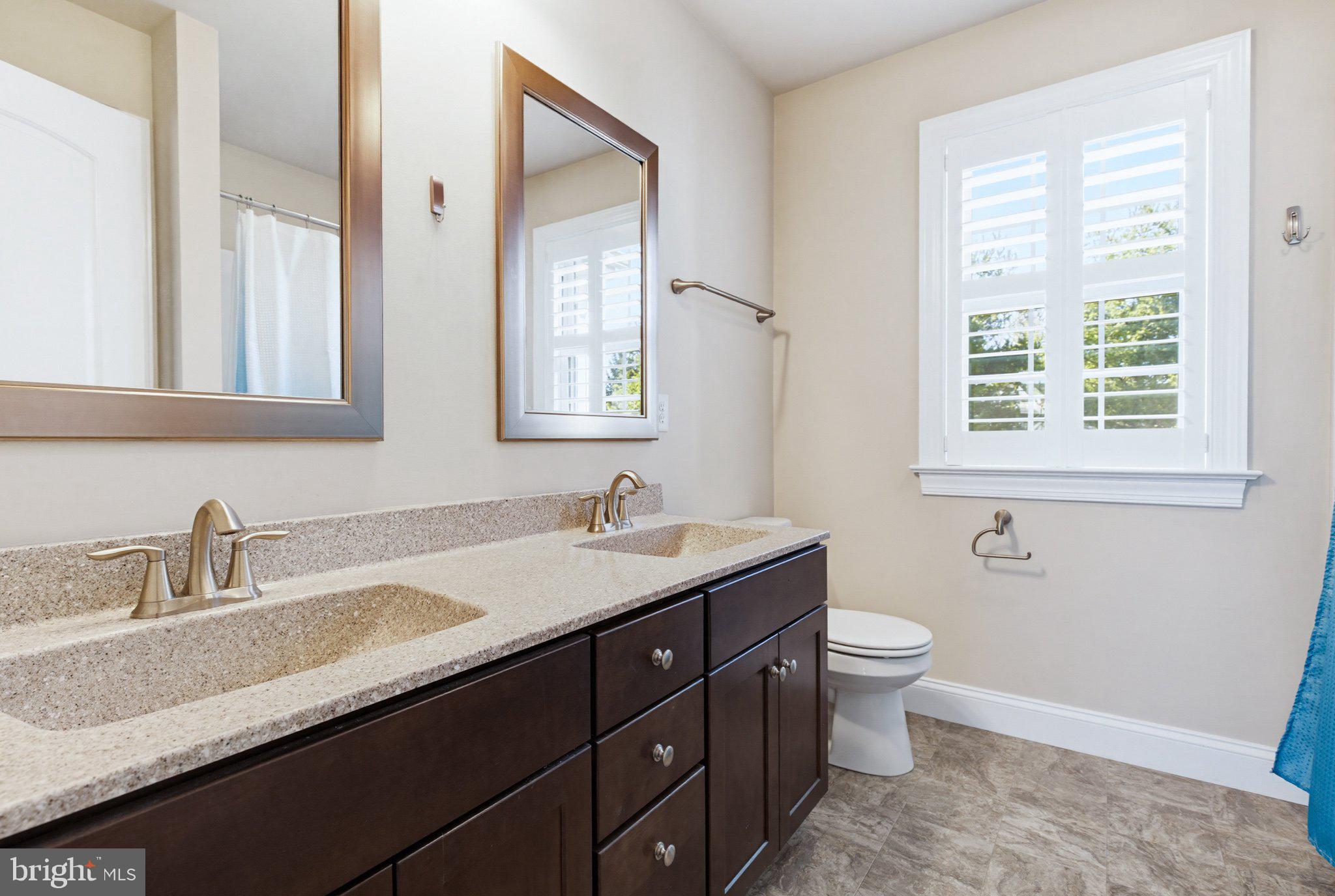 1021 Suffolk Drive Lititz, PA 17543 - Photo 31 of 44 a bathroom with a granite countertop sink a toilet and a mirror