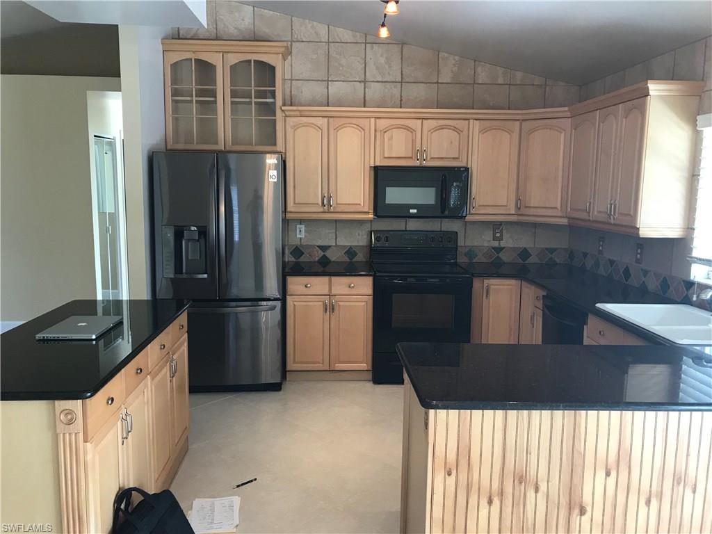 9108 Henry Road Fort Myers, FL 33967 - Photo 3 of 18 a kitchen with stainless steel appliances a refrigerator sink and microwave