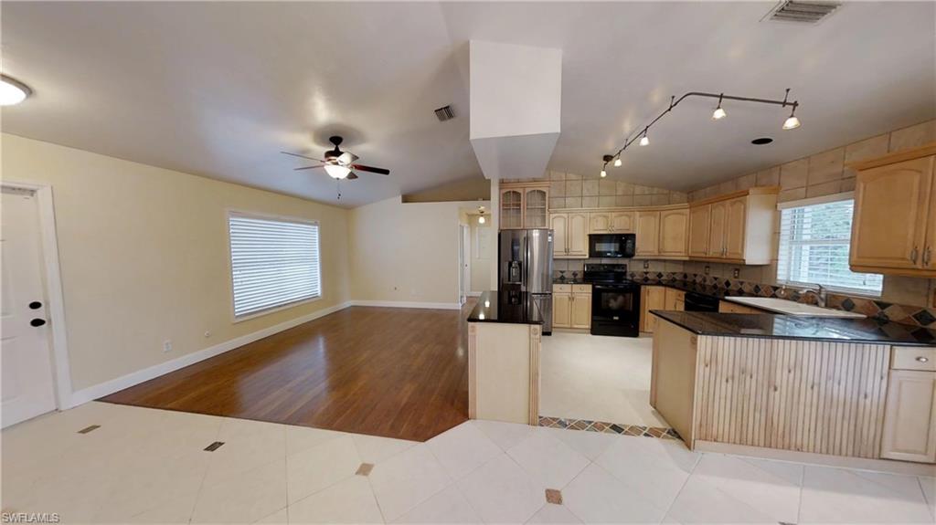 9108 Henry Road Fort Myers, FL 33967 - Photo 5 of 18 a large kitchen with stainless steel appliances kitchen island a large counter top and a stove