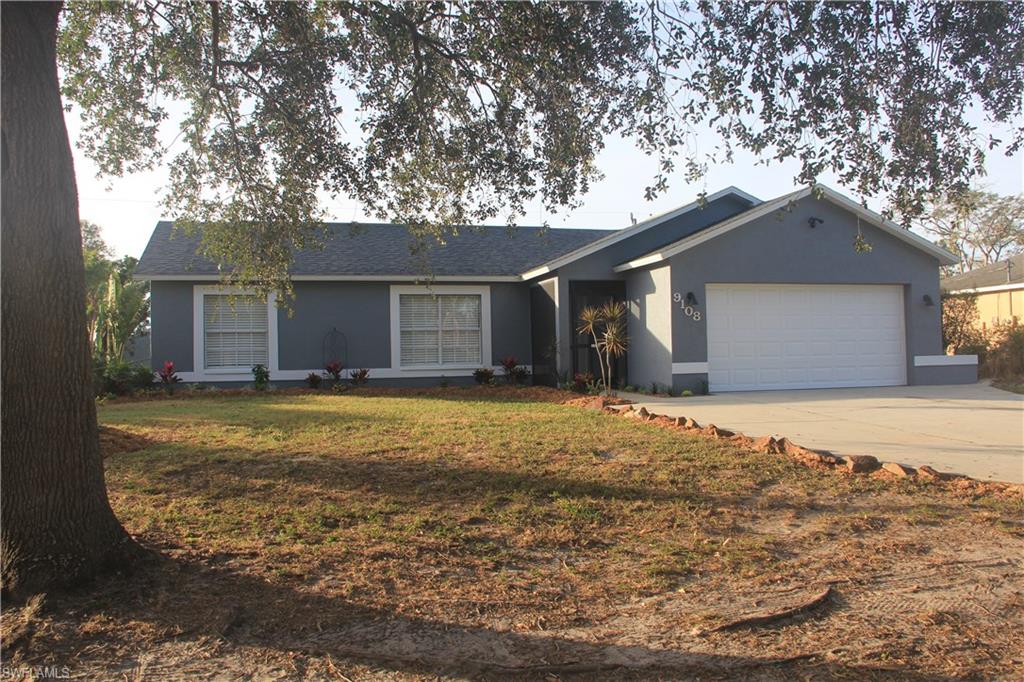 9108 Henry Road Fort Myers, FL 33967 - Photo 6 of 18 a front view of a house with a yard and garage