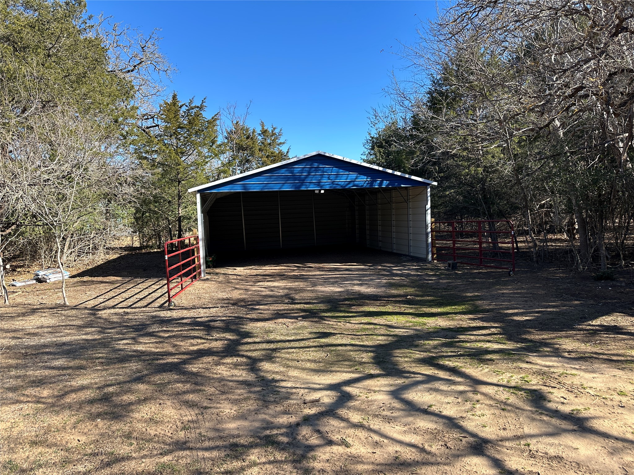 438 Mt Olive Road, Unit A Cedar Creek, TX 78612 - Photo 19 of 27 Garage featuring a carport and dirt driveway