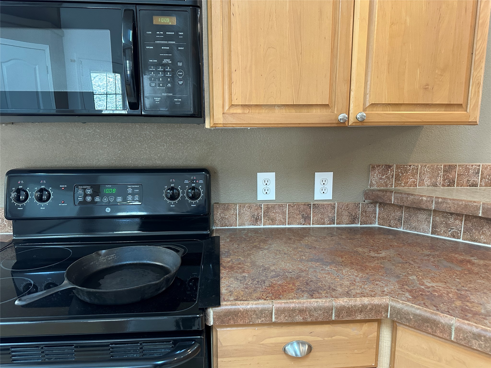 438 Mt Olive Road, Unit A Cedar Creek, TX 78612 - Photo 9 of 27 Kitchen view of black appliances, light wood finish cabinetry, and dark countertops