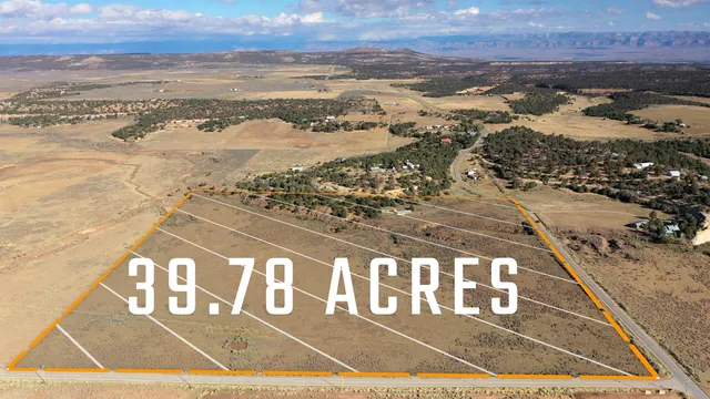 an aerial view of house with yard and mountain view in back