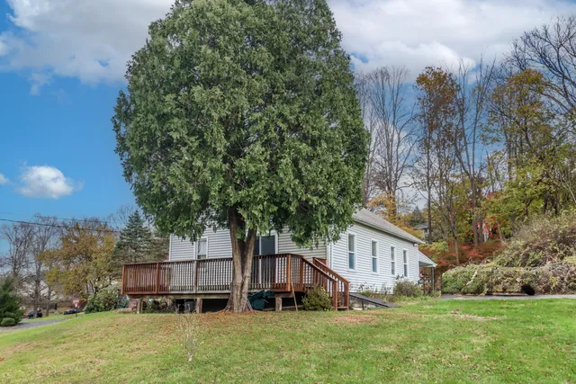 a house that has a tree in front of a house