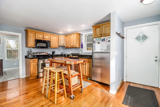 a kitchen with granite countertop a refrigerator stove top oven and sink