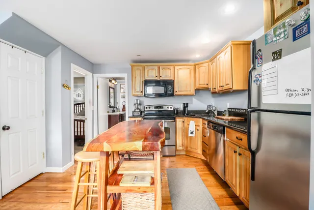 a kitchen with stainless steel appliances granite countertop a refrigerator and a stove top oven
