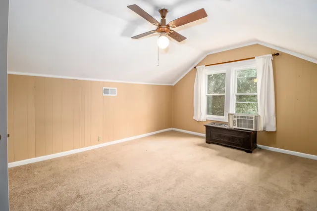 an empty room with a ceiling fan and a window