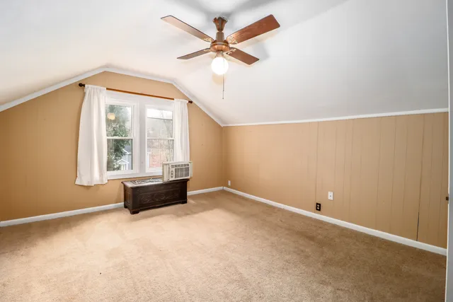 an empty room with windows and ceiling fan
