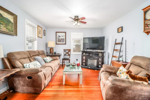 a living room with furniture a flat screen tv and a fireplace