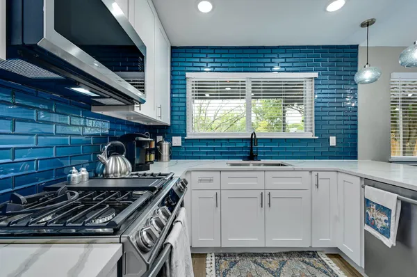 a kitchen with white cabinets and a stove top oven