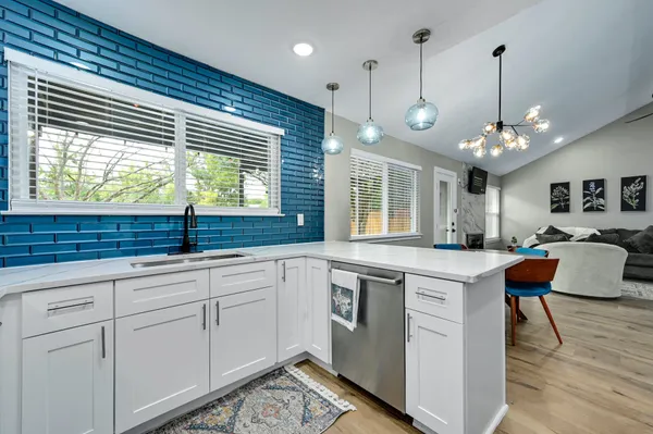 a large kitchen with kitchen island a large window and a sink