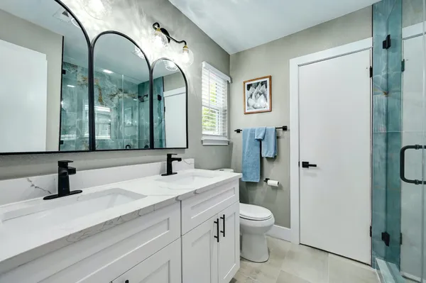 a bathroom with a double vanity sink mirror and toilet