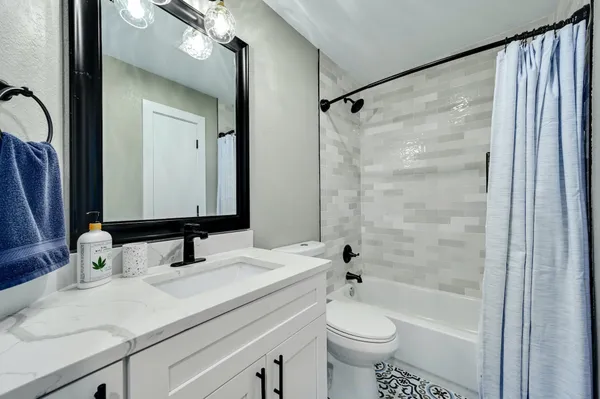 a bathroom with a granite countertop sink toilet and shower