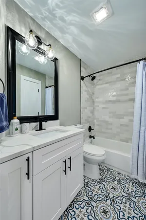 a bathroom with a double vanity sink toilet mirror and shower