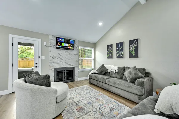 a living room with furniture a flat screen tv and a fireplace