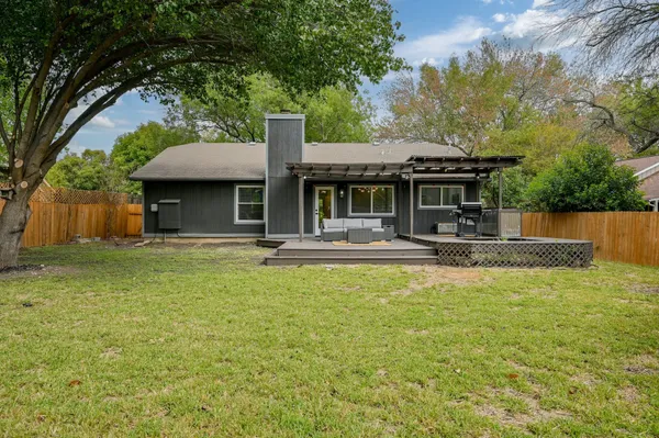 a view of a house with backyard and tree