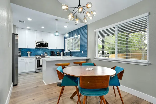 a dining room with wooden floor and a chandelier