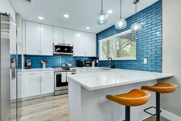 a kitchen with stainless steel appliances a stove a sink and a refrigerator