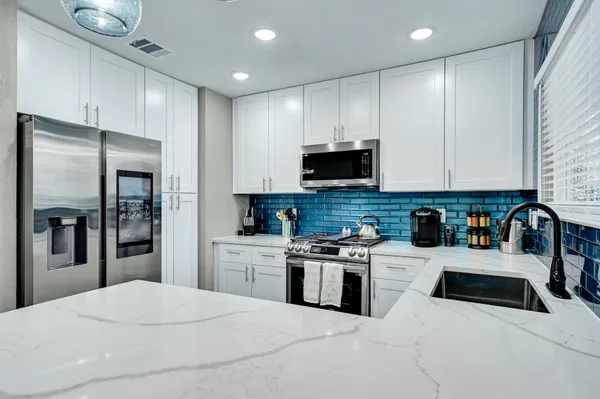 a kitchen with stainless steel appliances a refrigerator sink and microwave