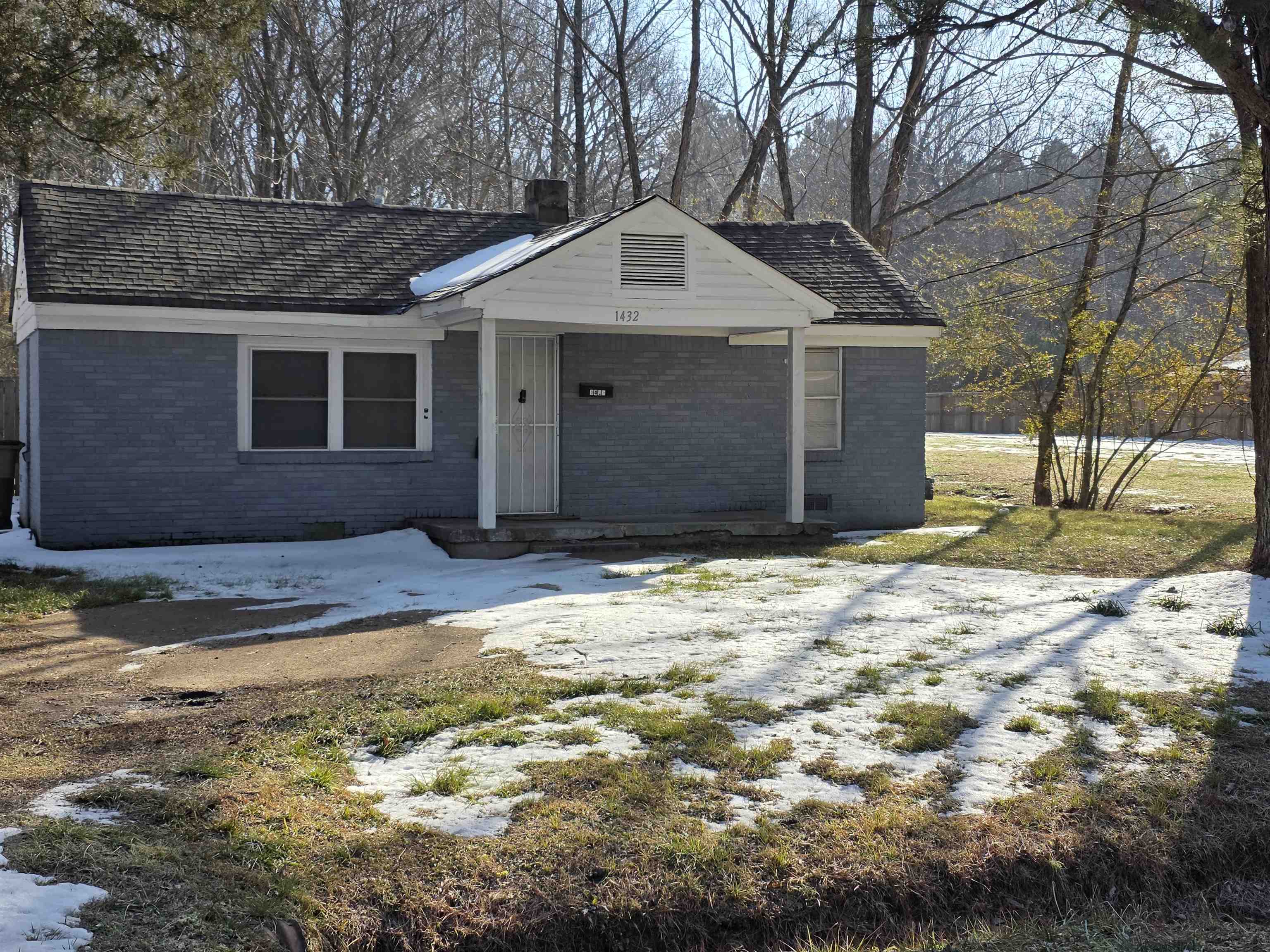 Ranch-style home featuring brick siding, a chimney, and a porch