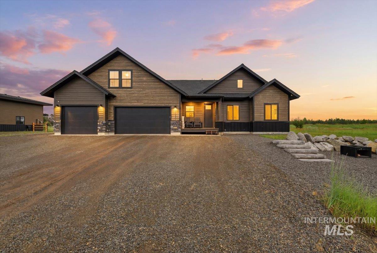 13152 Hawks Bay Road Donnelly, ID 83615 - Photo 1 of 29 Contemporary home with dark wood-finish siding, stone accents, and a two-car garage