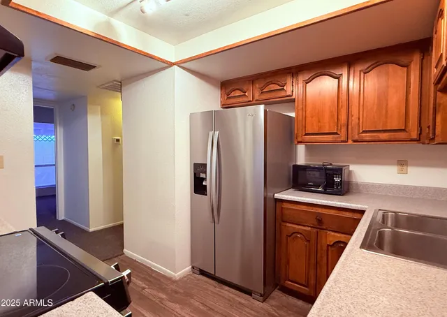 a kitchen with stainless steel appliances granite countertop a refrigerator and a sink