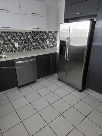 a kitchen with granite countertop a refrigerator and a stove