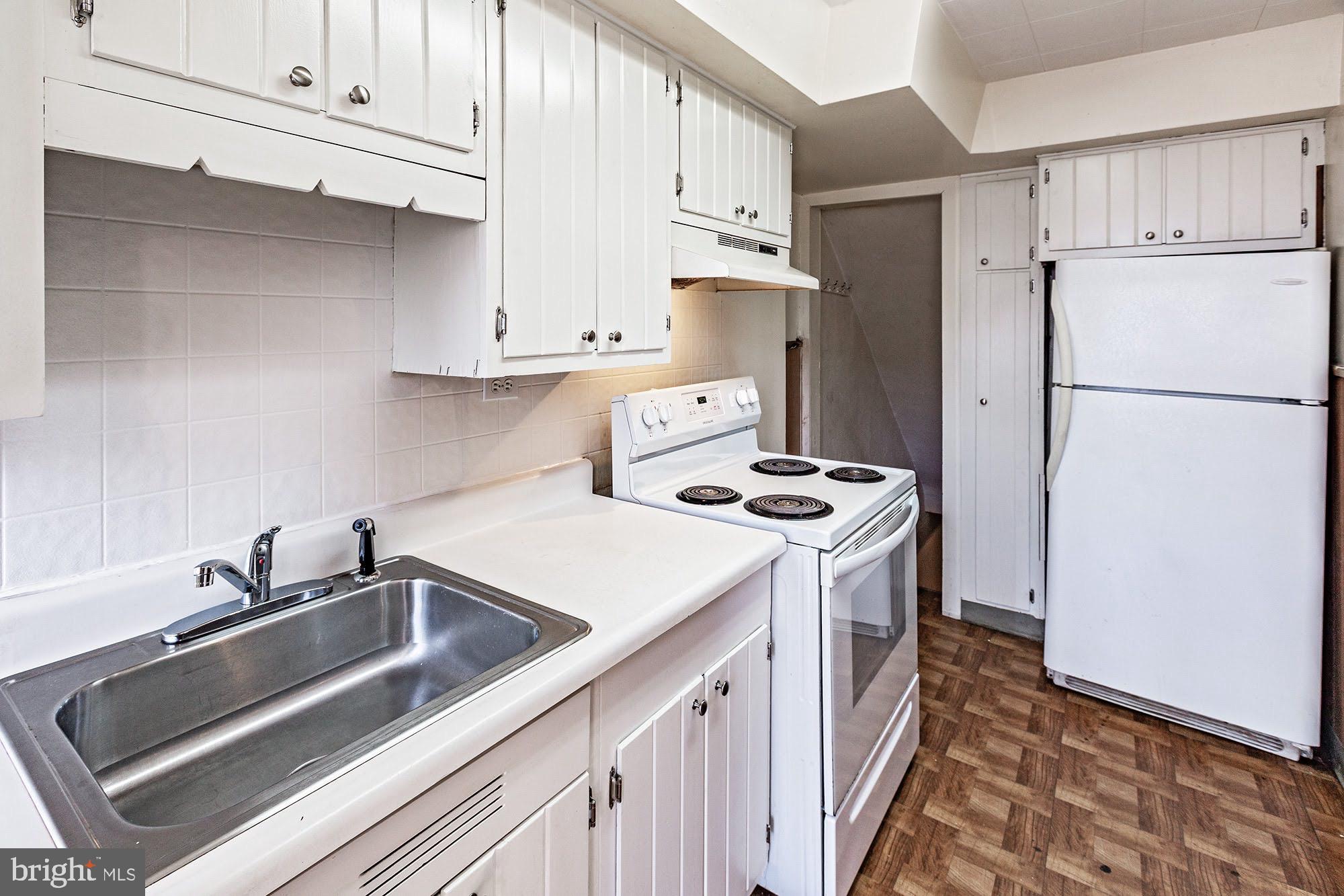 3312 West 13th Street Chester, PA 19013 - Photo 6 of 13 a kitchen with stainless steel appliances a refrigerator a sink a stove and white cabinets