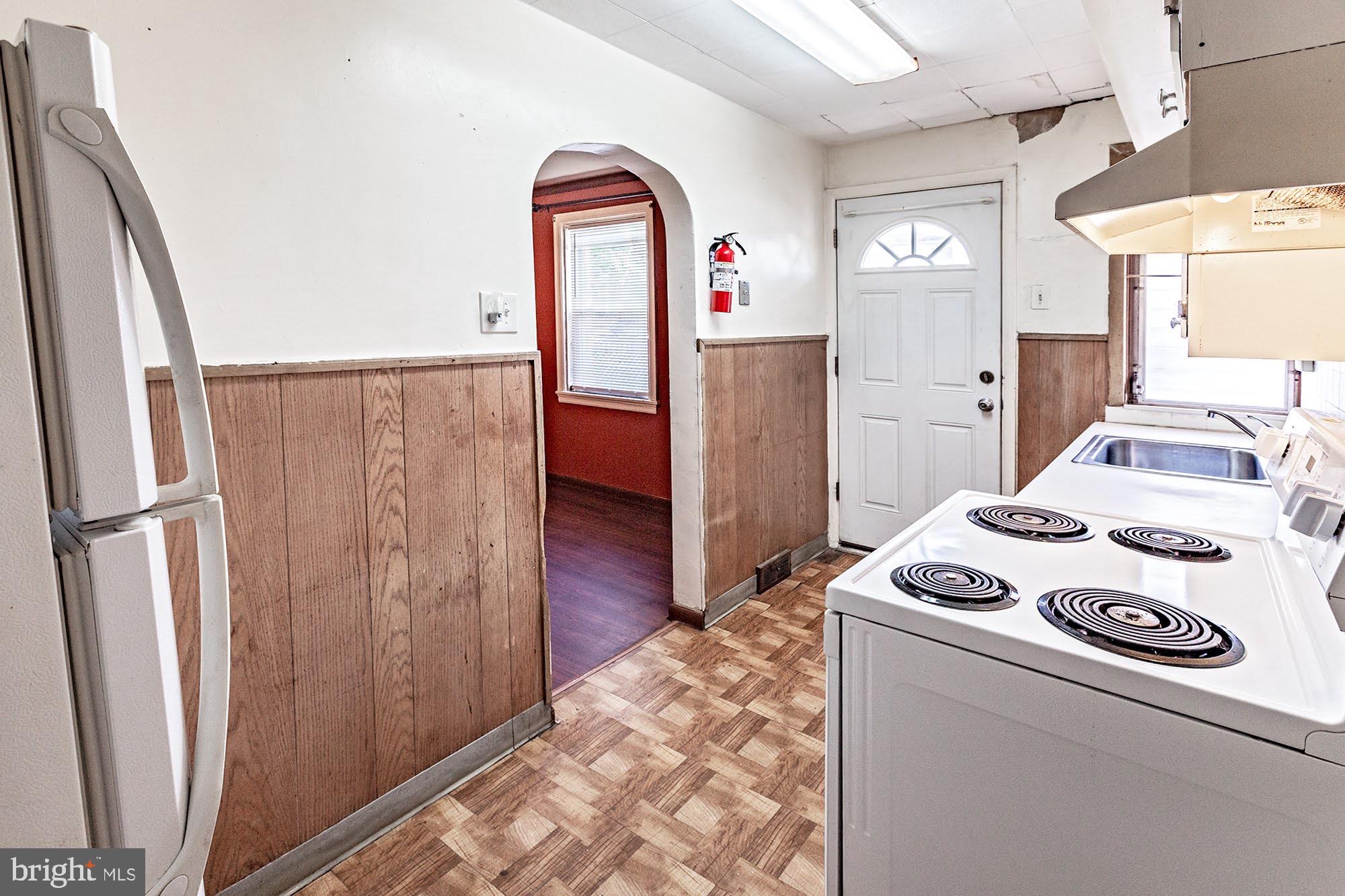 3312 West 13th Street Chester, PA 19013 - Photo 7 of 13 a view of washer and dryer with kitchen in the background