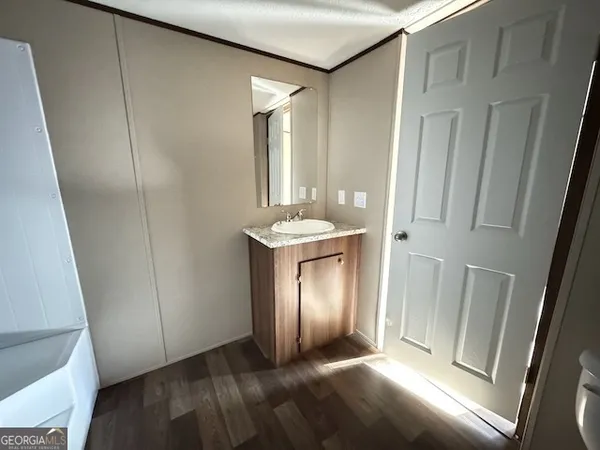 a view of a kitchen with wooden floor and a window