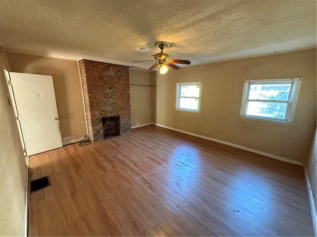 516 Armandale Street Pittsburgh, PA 15212 - Photo 13 of 17 an empty room with wooden floor fireplace and windows