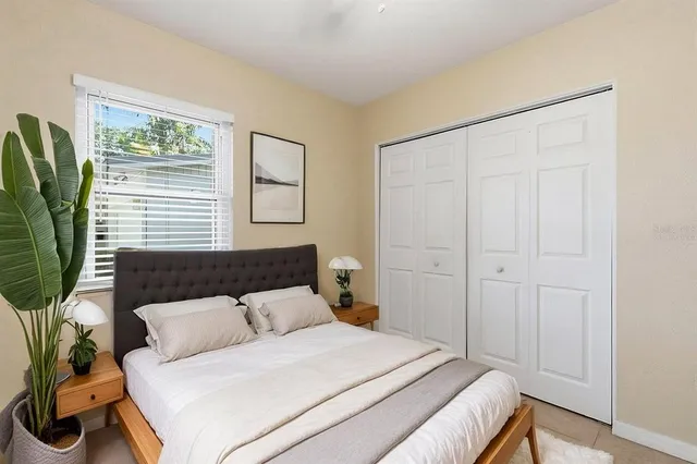 a bedroom with a large bed and a potted plant