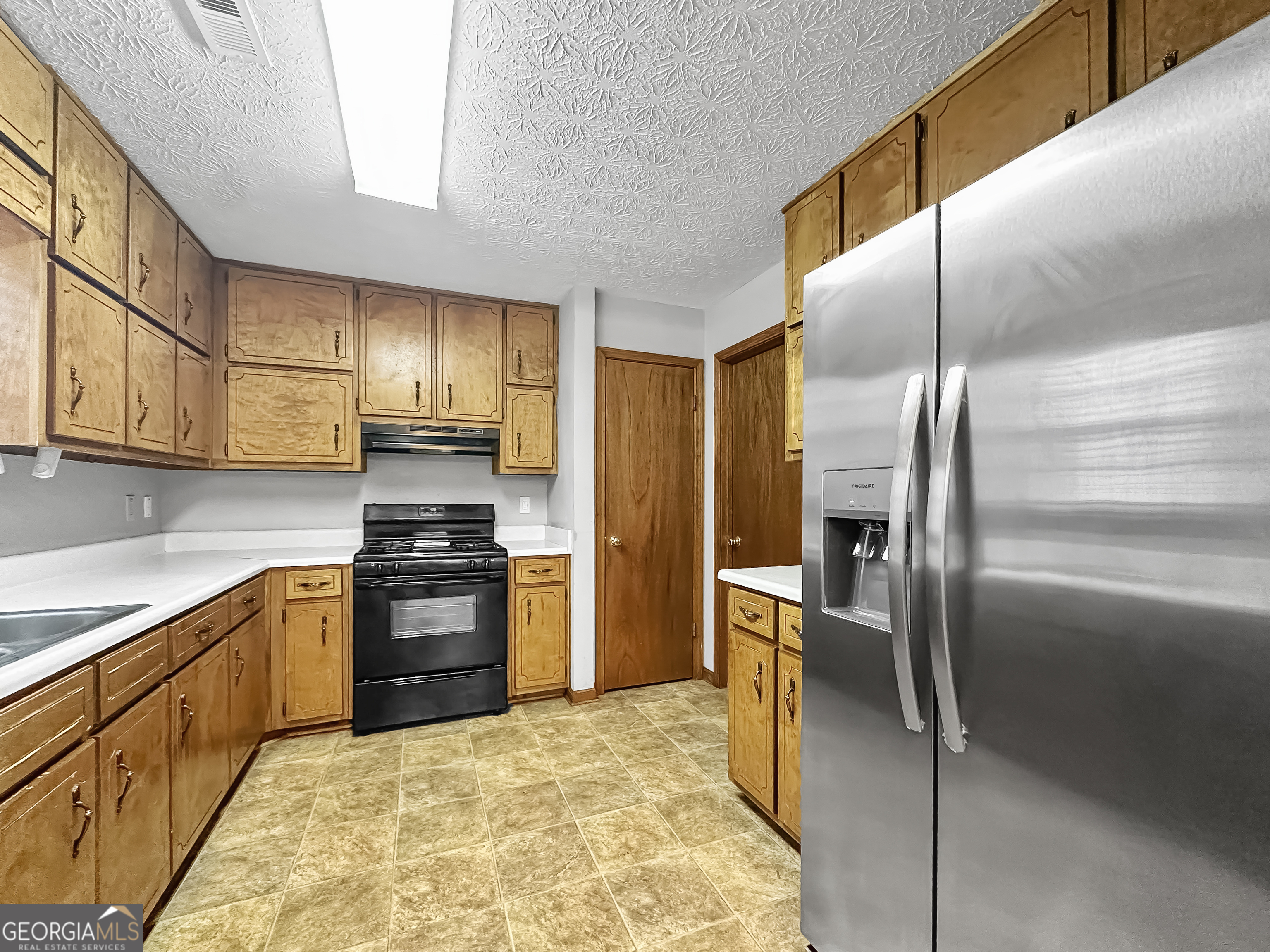 290 Cornwallis Way Fayetteville, GA 30214 - Photo 7 of 18 a kitchen with stainless steel appliances granite countertop a refrigerator a stove and a sink