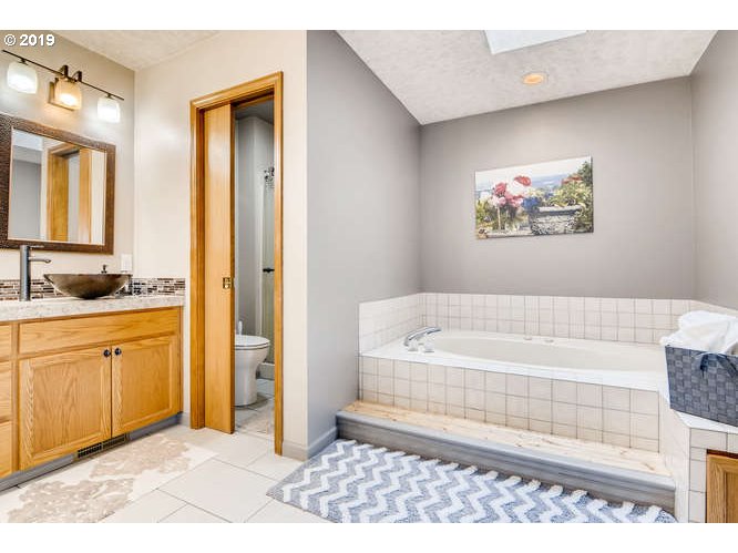13848 Southwest Whitmore Road Hillsboro, OR 97123 - Photo 18 of 29 a spacious bathroom with a tub a sink and a shower