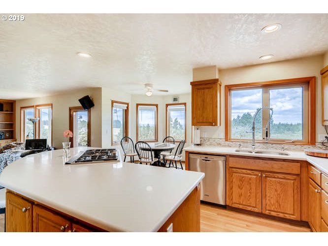 13848 Southwest Whitmore Road Hillsboro, OR 97123 - Photo 9 of 29 a kitchen with kitchen island granite countertop a stove a sink a dining table and chairs