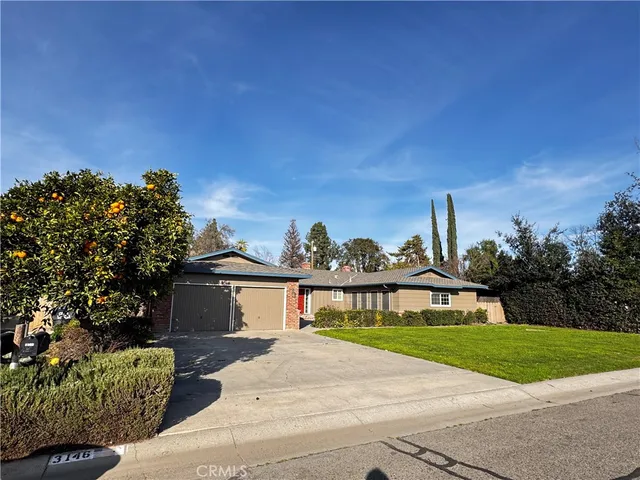 a front view of a house with a garden and yard